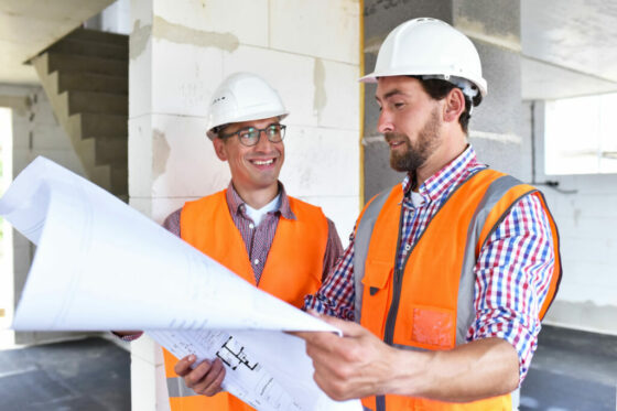 Bauleiter und Architekt vor Ort beim Neubau eines Hauses im Rohb